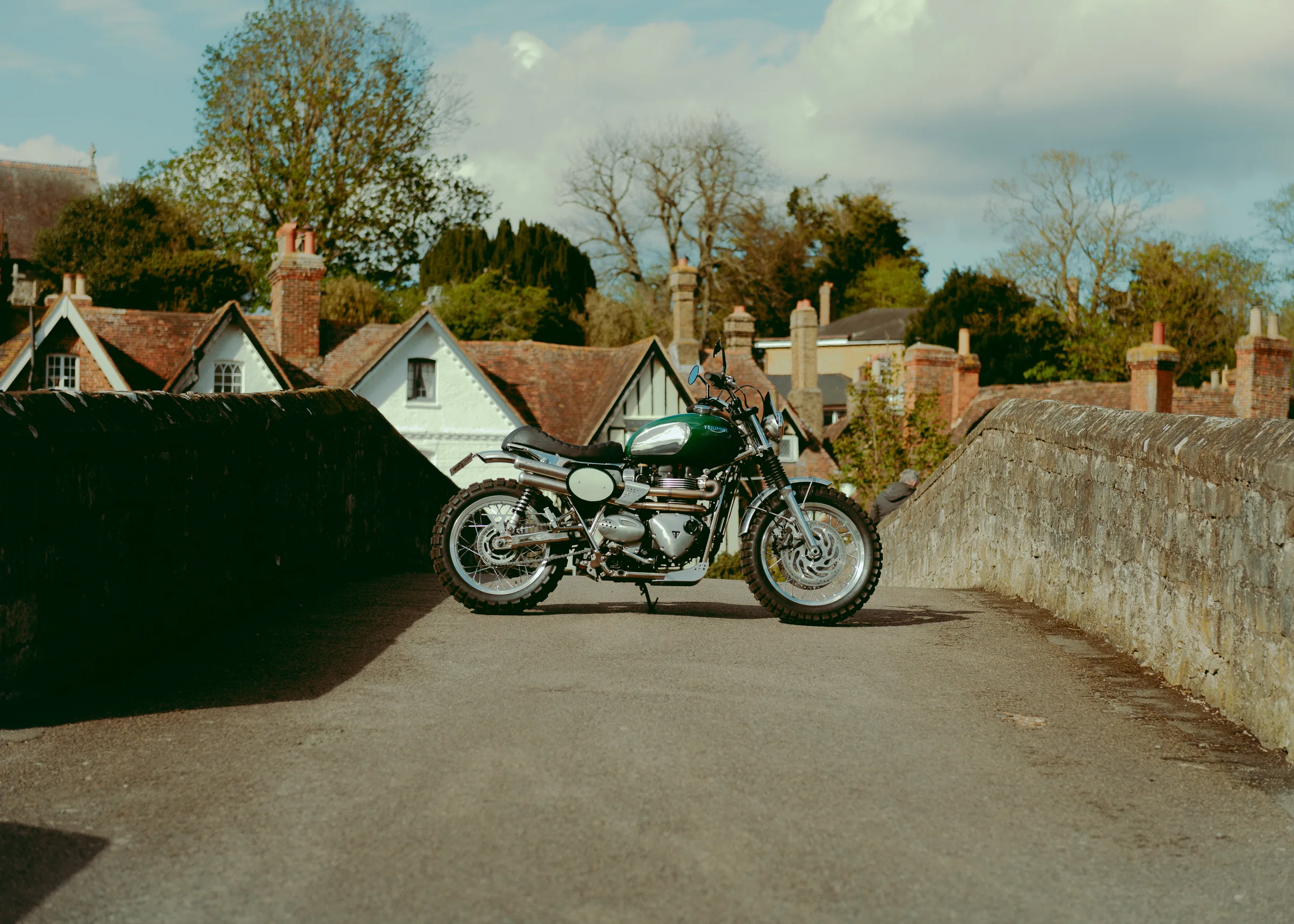 Triumph Legend FCR Original verte sur un pont en pierre dans un village anglais