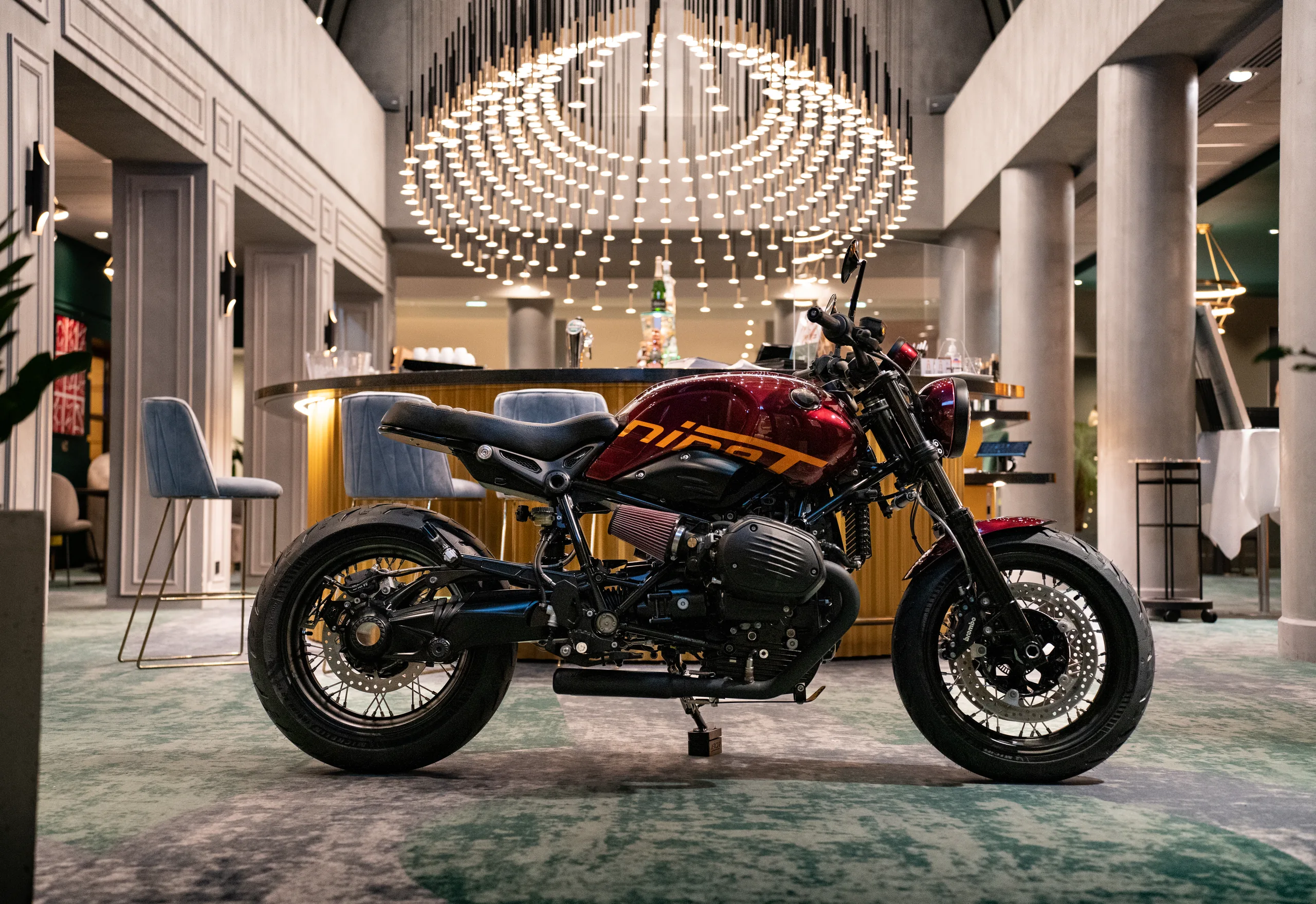 Vue latérale d'une BMW R nineT Urban FCR Original rouge dans un hall d'exposition
