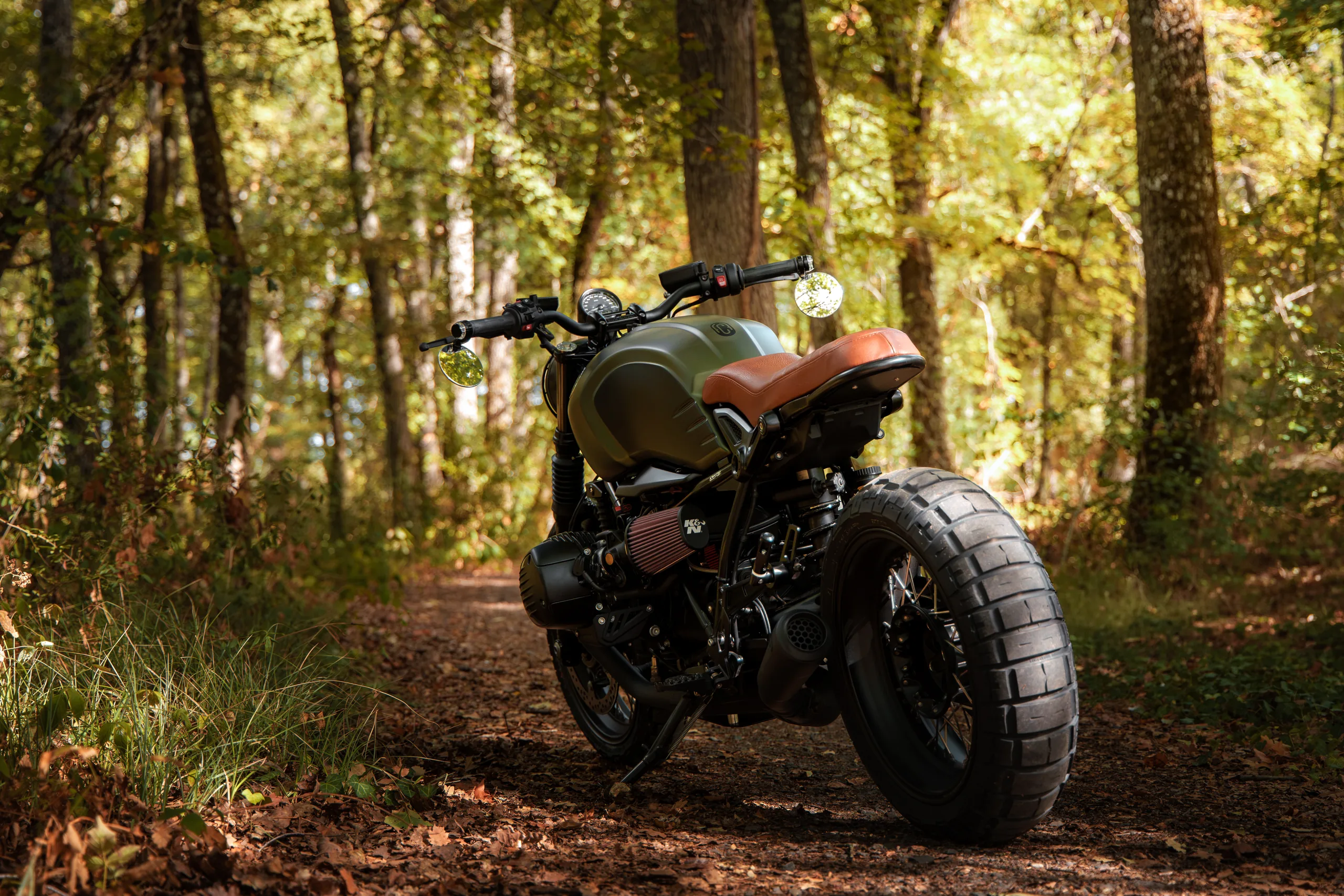 BMW R nineT FCR Original kaki avec pneus à crampons dans un sous-bois