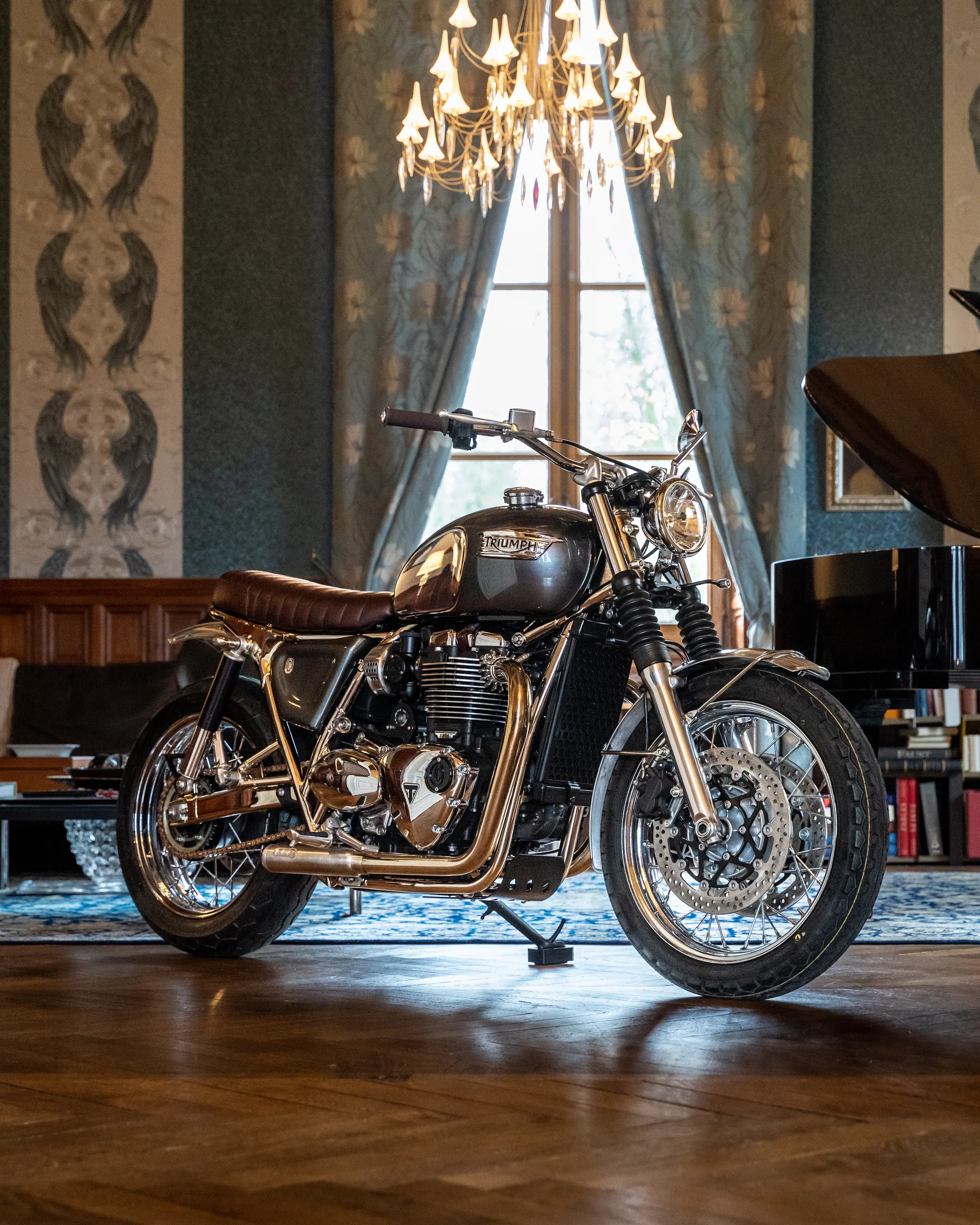 Triumph Bonneville Ride & Chrome FCR Original bronze et chrome dans un salon sous un lustre