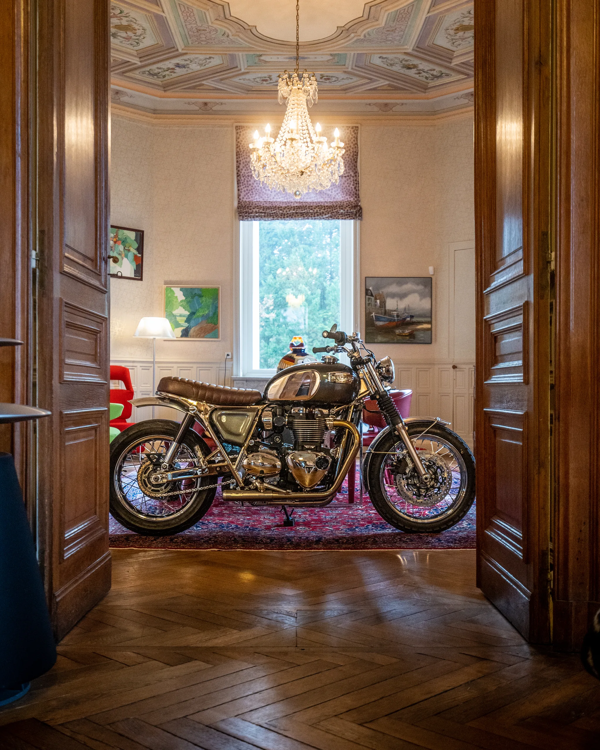 Triumph Ride & Chrome FCR Original bronze exposée dans un salon bourgeois avec lustre en cristal