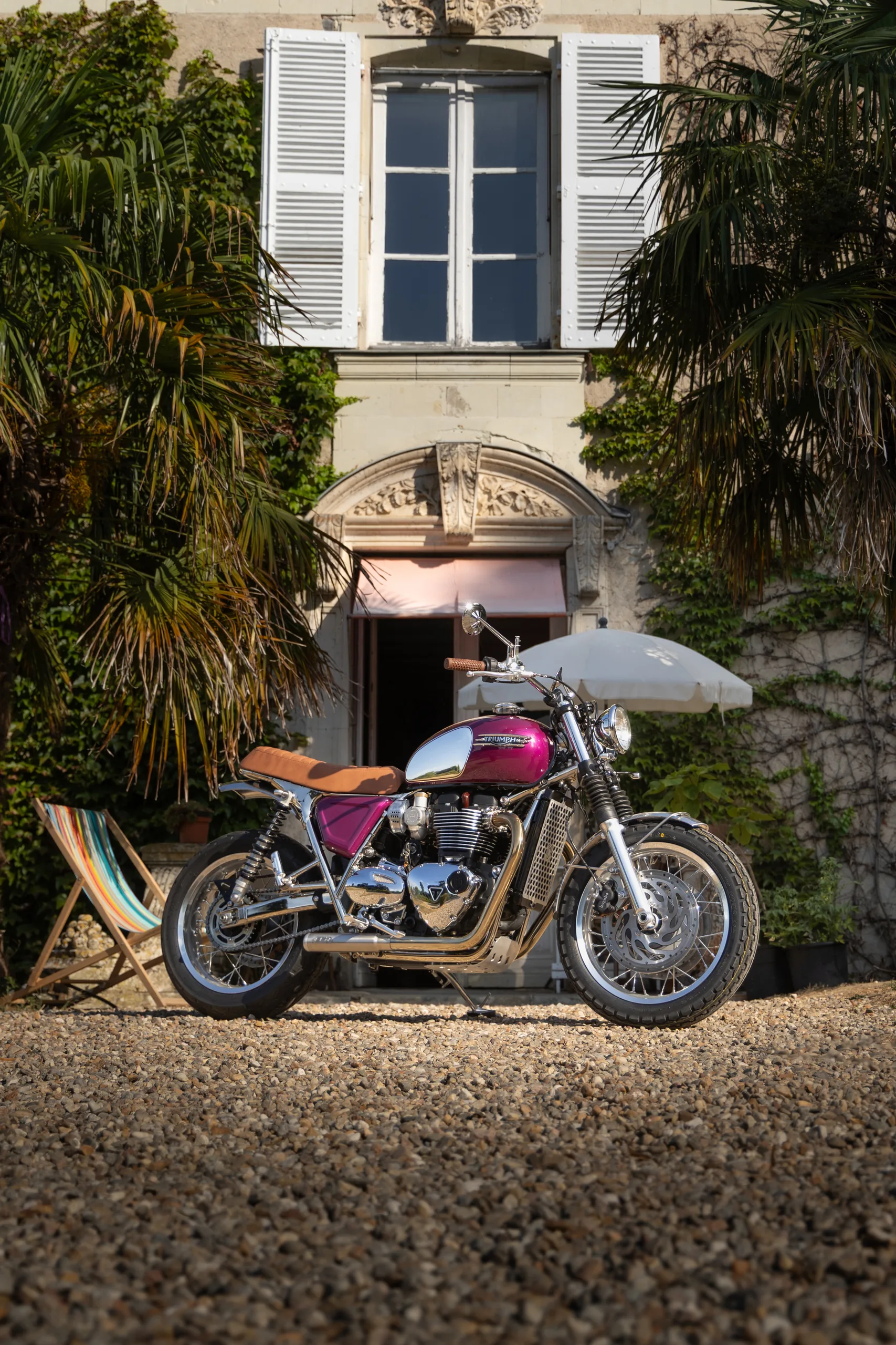 Triumph Ride & Chrome FCR Original rose et chrome devant une maison de maître avec transat