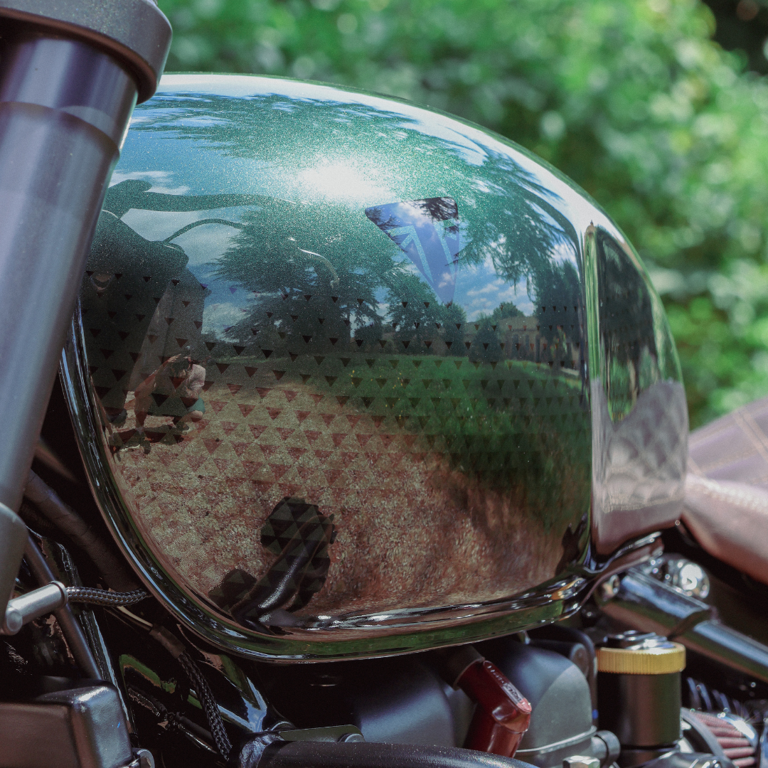 Peinture en vert anglais profond avec des motifs géométriques modernes et des détails en feuille d'or appliqués à la main sur la Triumph 1200 Bobber.