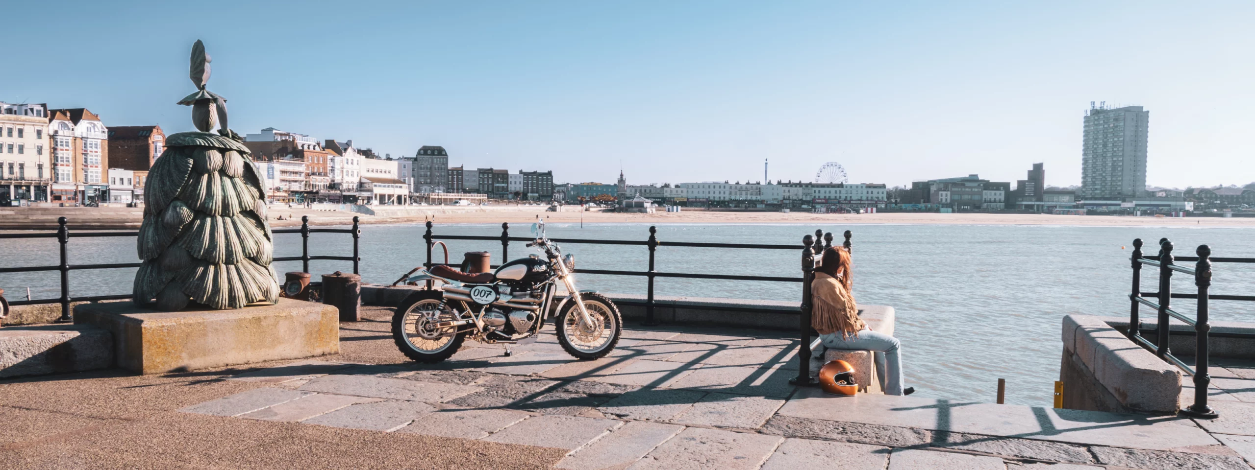 Moto Triumph Legend Bonneville T100 FCR Original à Margate, vue de derrière sur fond urbain côtier