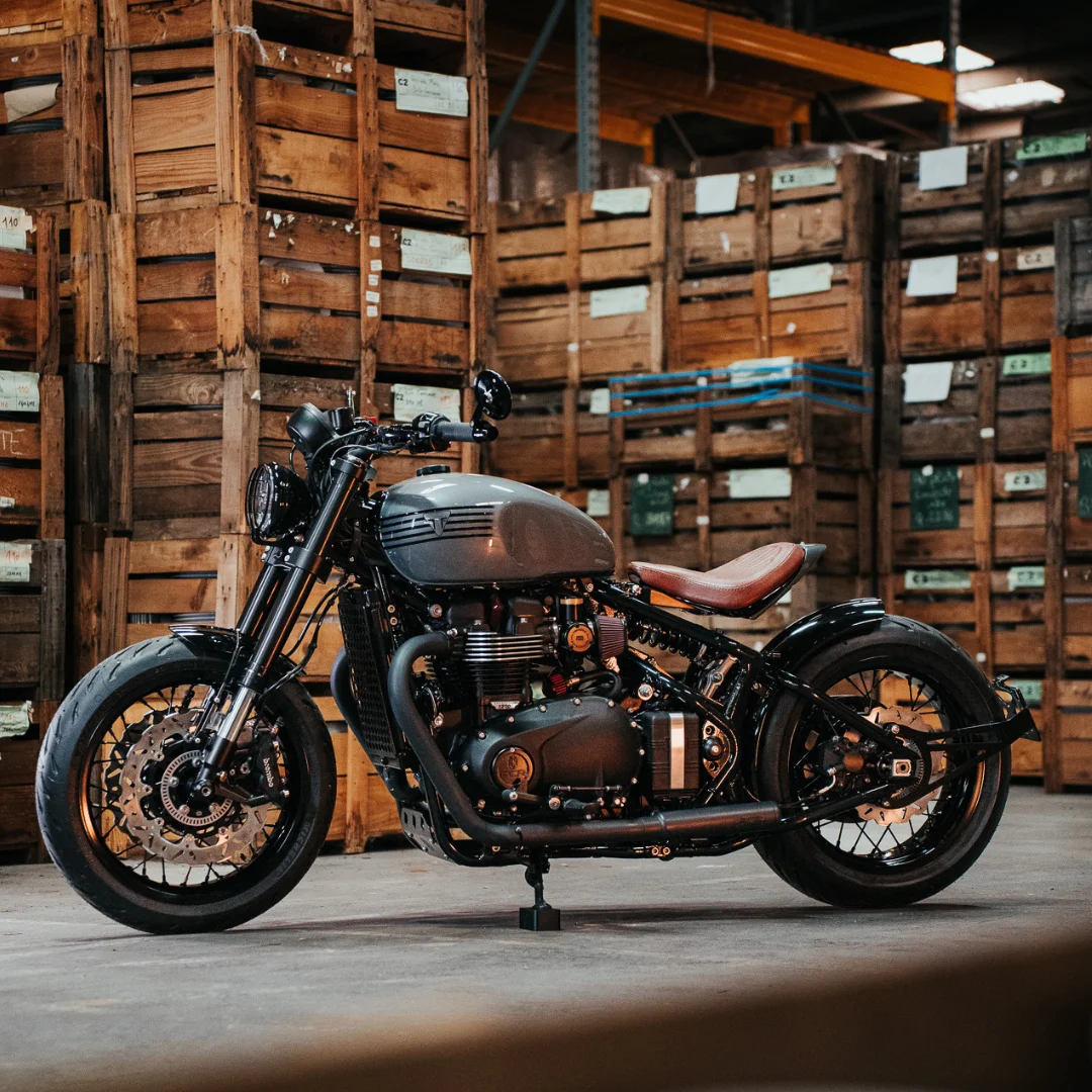 Triumph Bobber préparé par FCR Original pris en photo dans un entrepot