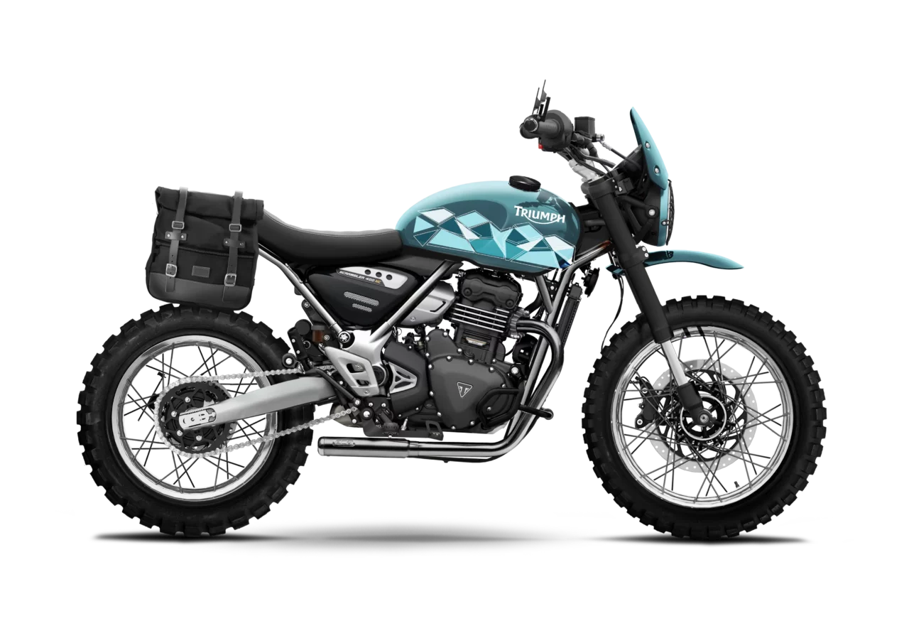Triumph Speed 400 XC Scrambler Escape Ice Blue préparée par FCR Original, équipée de pneus off-road, d’un sabot moteur, d’un phare haut avec casquette rallye et d’une sacoche latérale, décorée d’un motif géométrique bleu.