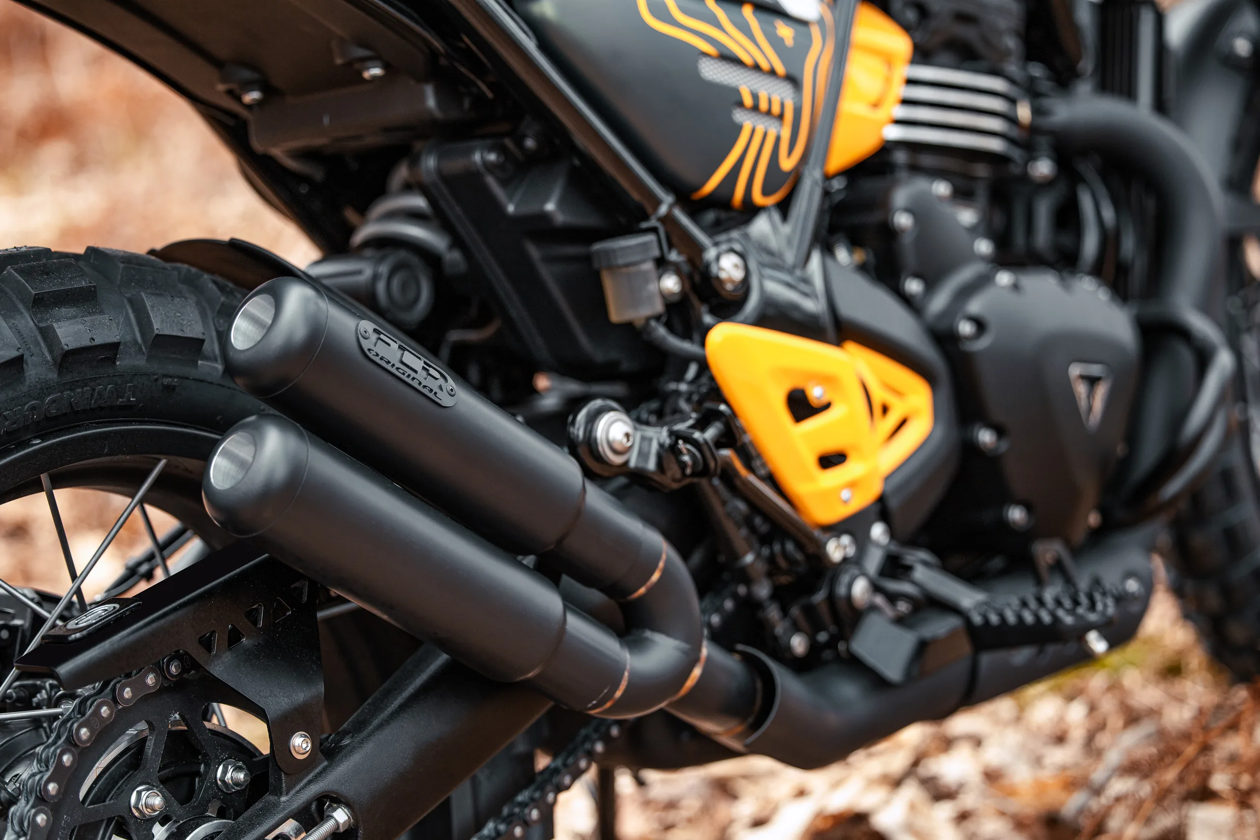 Échappement noir FCR Original et cache latéral jaune d'une Triumph Scrambler 400 Escape