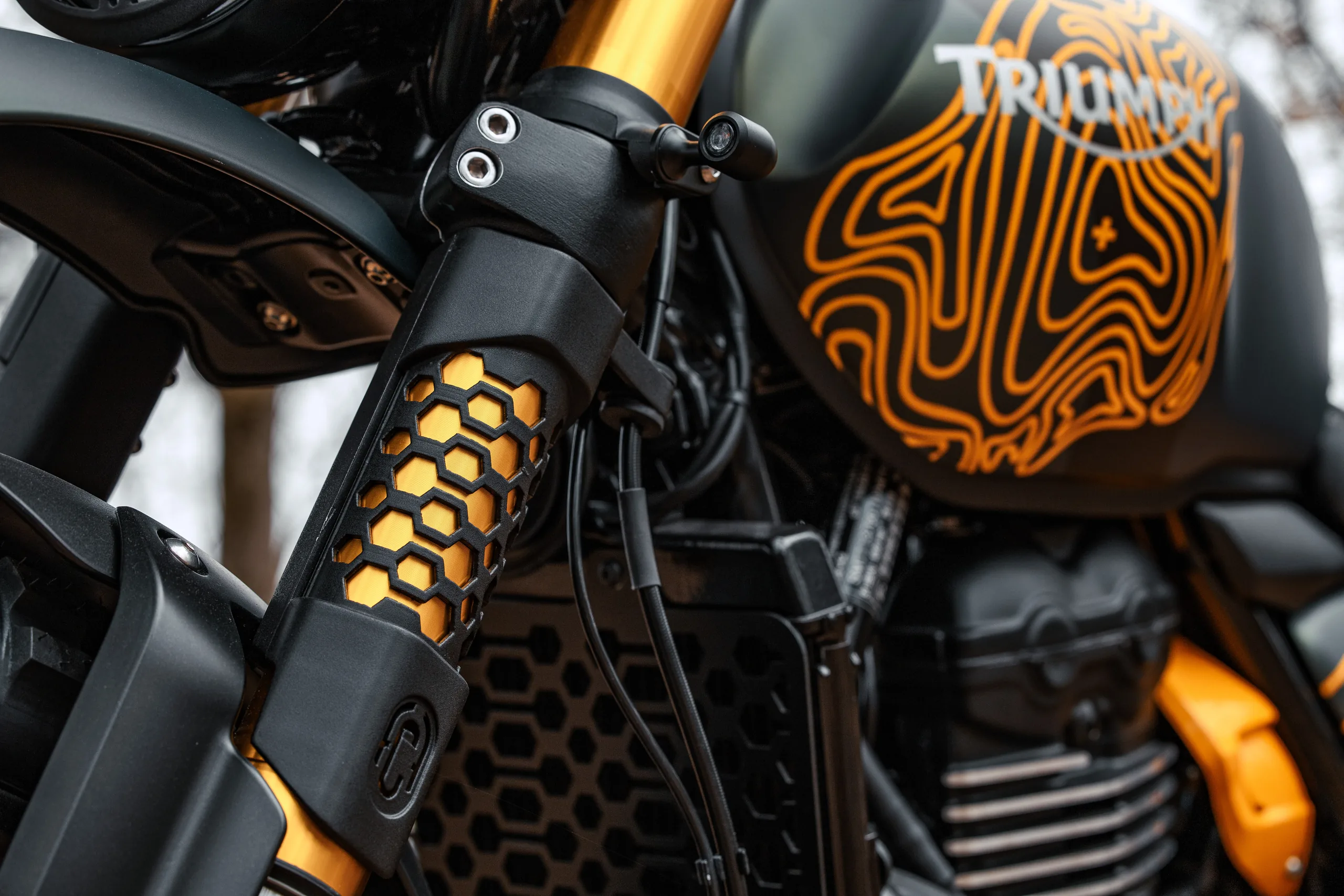 Détail de la fourche dorée et du réservoir à motif topographique orange de l'Escape FCR Original
