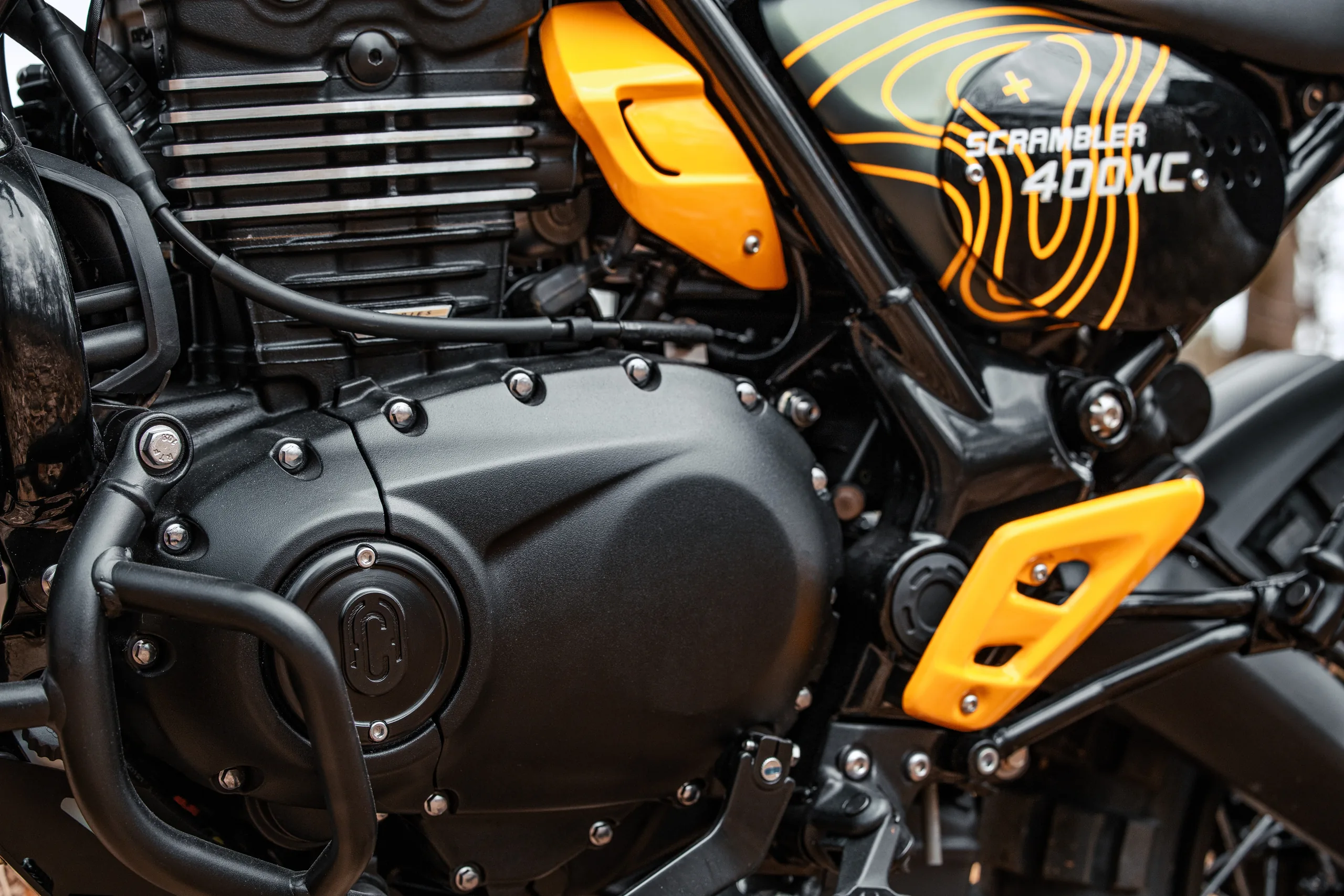 Détail du cache latéral jaune et du réservoir à motifs d'une Scrambler 400 XC Escape FCR Original