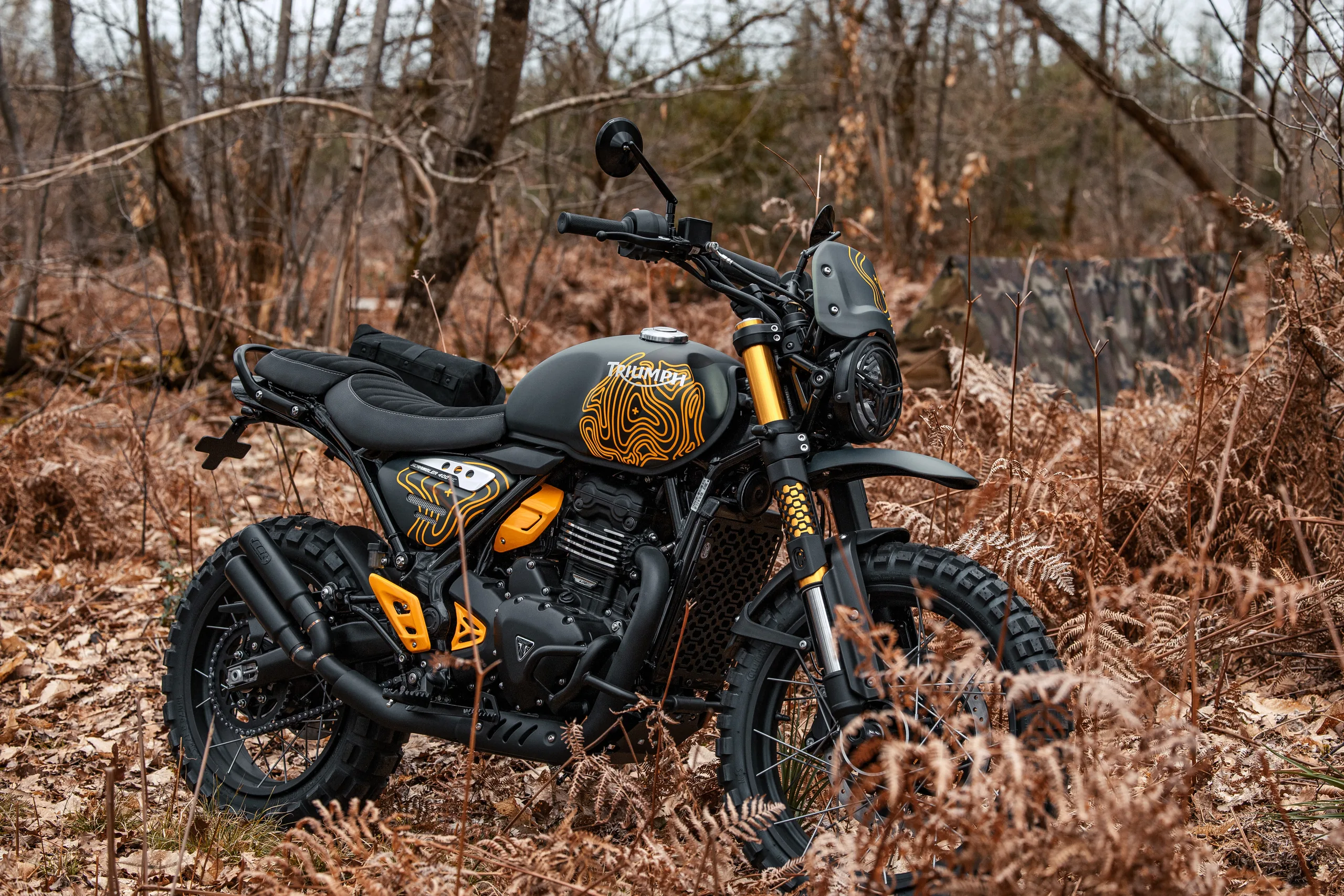 Triumph Scrambler 400 XC Escape FCR Original grise à motifs topographiques orange dans les fougères