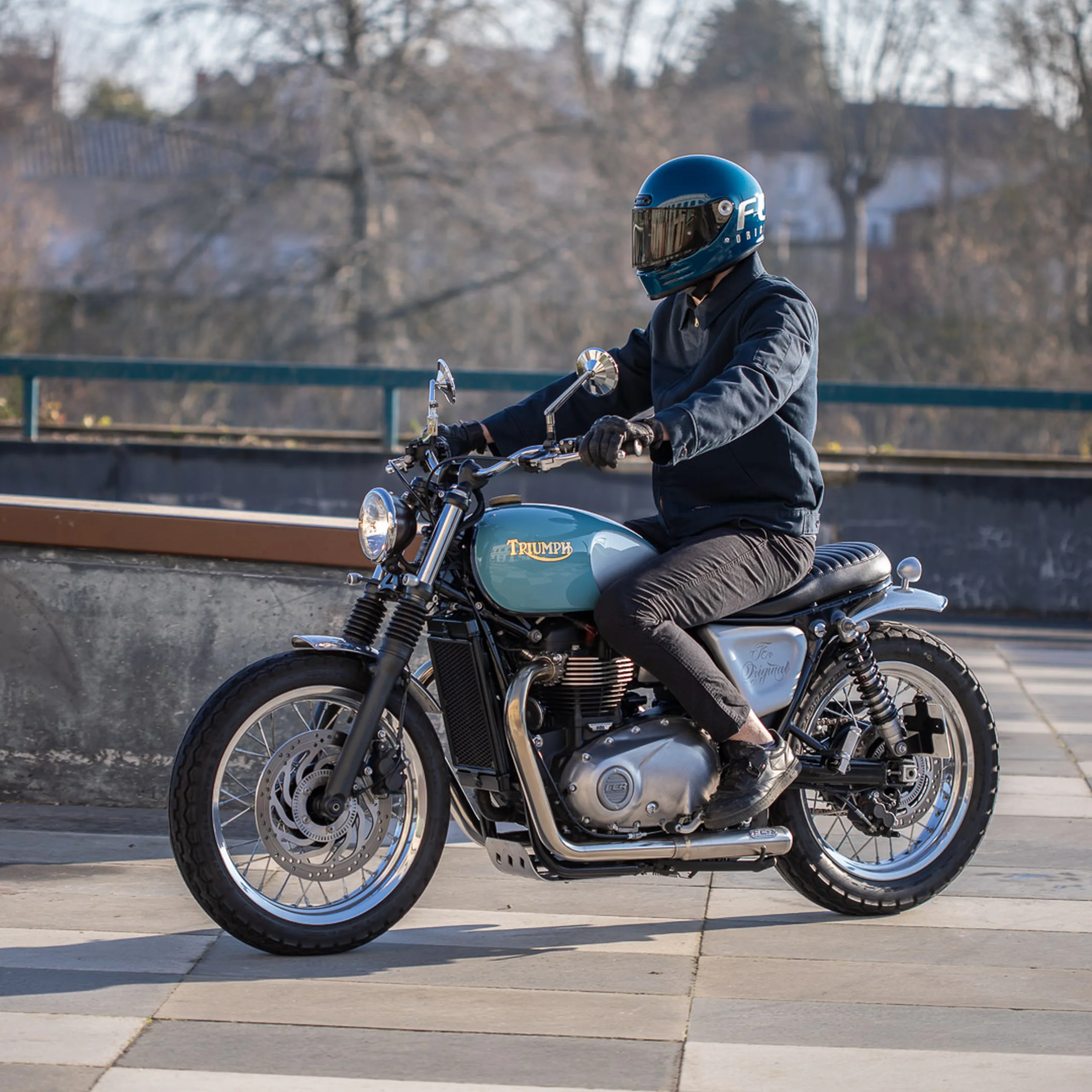 Pilote au guidon d'une Triumph Bonneville préparée par FCR Original, moto A2 custom