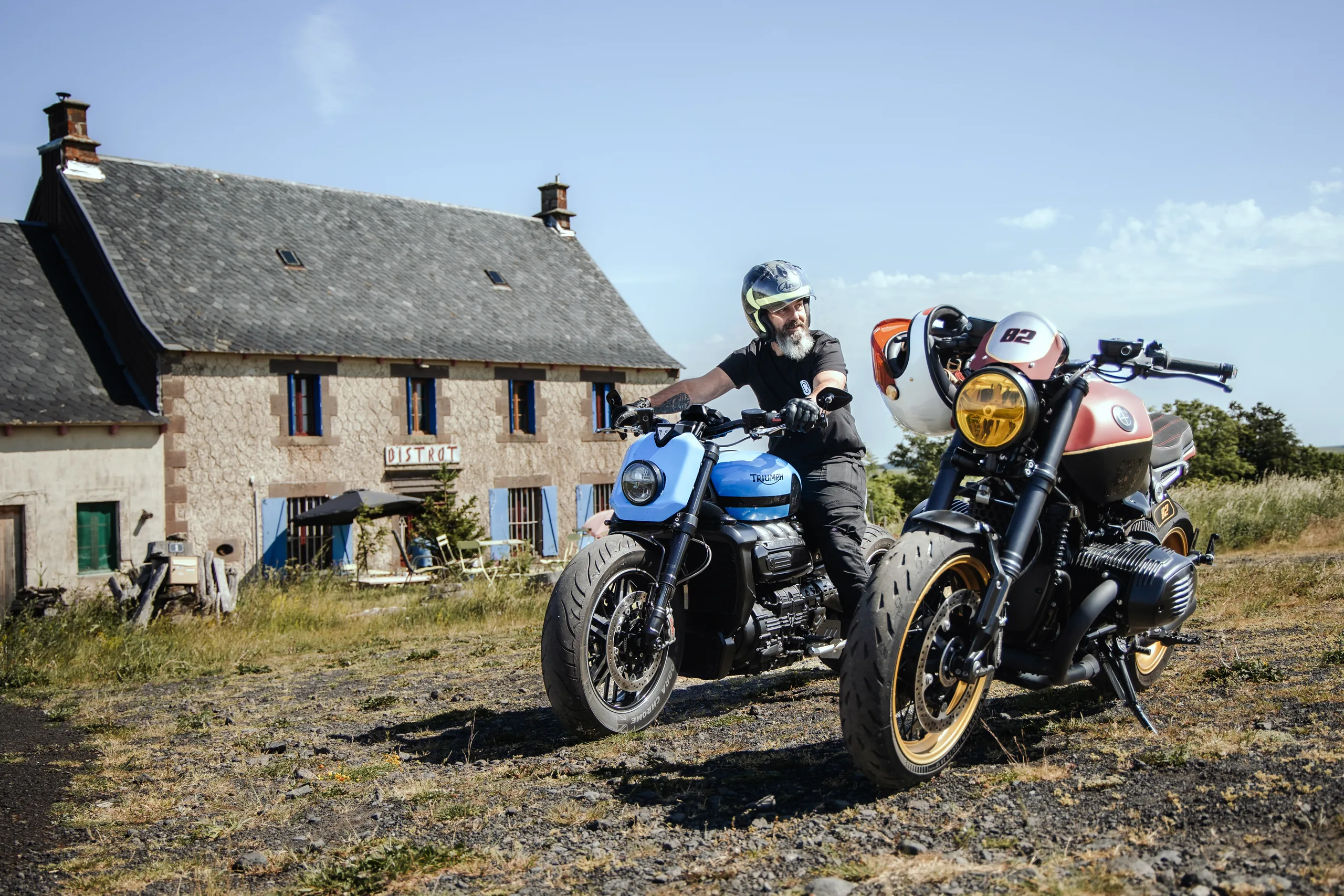 Pilote sur la Triumph Rocket 3 FCR Original devant une maison en pierre lors du Brett Classic Tour